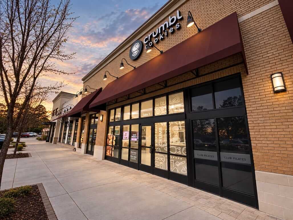 Crumbl Cookies storefront with red awning at dusk